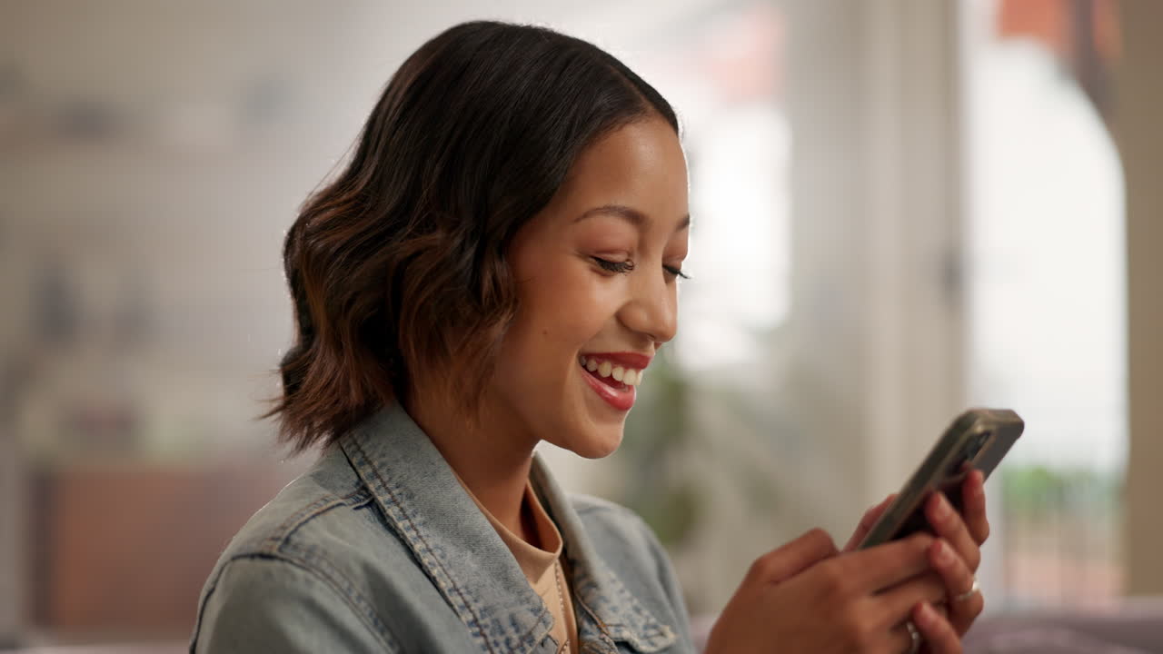 Woman smiling and using her phone indoors