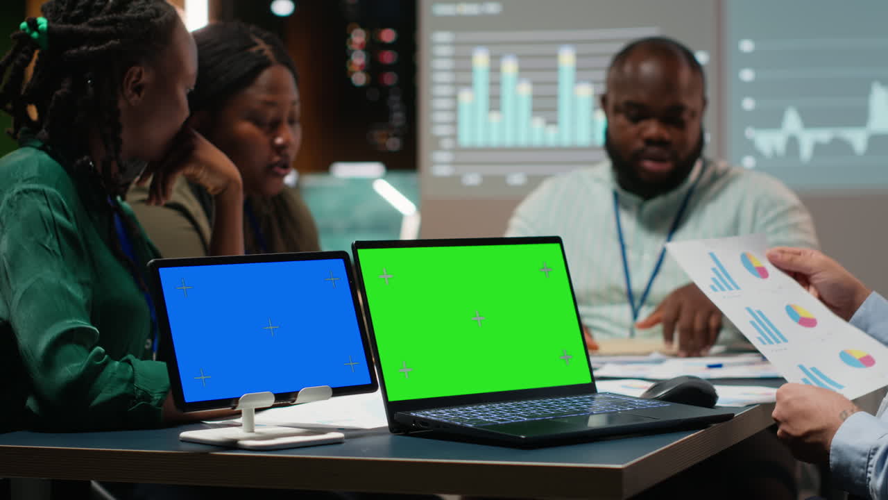 Coworkers hosting business meeting at night with green screen in strategy room
