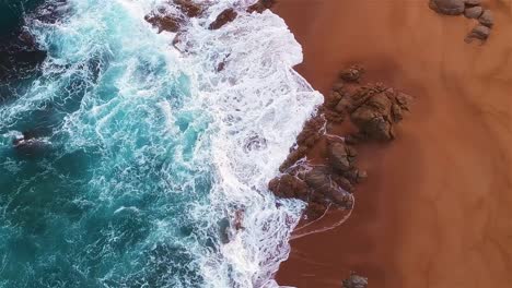 Aerial-top-shot-of-a-coastline-where-the-ocean-meets-the-shore