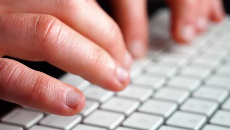 hands and fingers typing on keyboard on computer - closeup shot