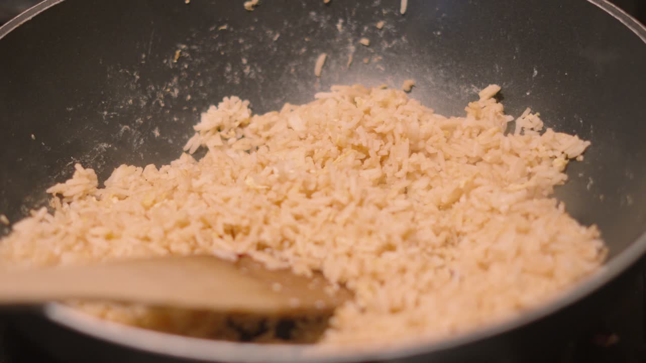 Egg Fried Rice in Hot Wok Pan with Wooden Spatula After Cooking on High Heat. Traditional Asian Oriental Cuisine Food Footage 4K