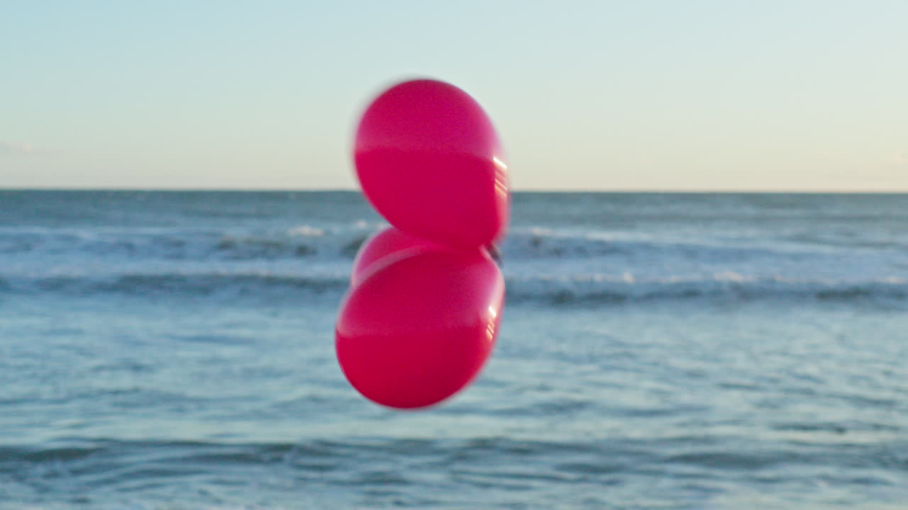 tres globos rojos pasan por la vista al mar desenfocada