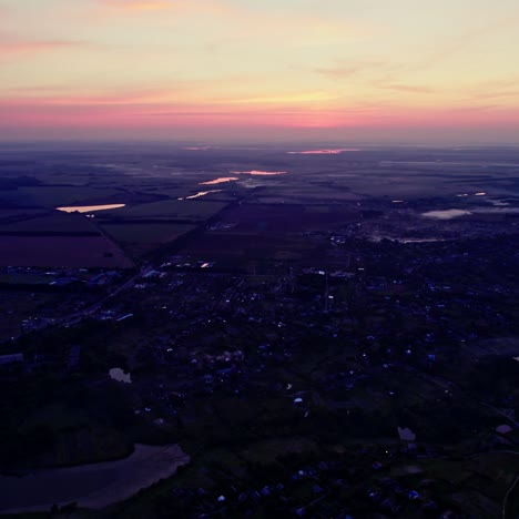sunrise over rural landscape with fields, river and town