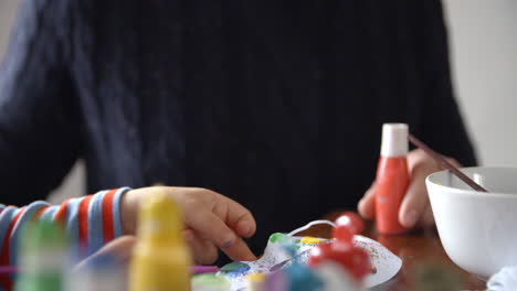 father and daughter painting masks at home together