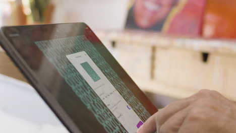 cerrar anciano caucásico usando el dedo en la pantalla de la tableta ipad