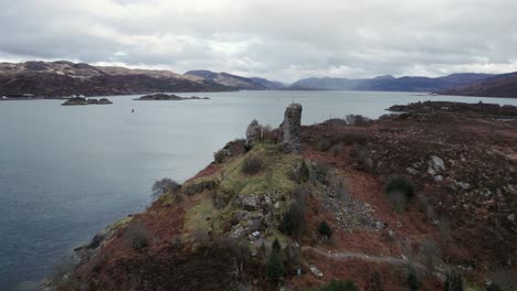 fast drone panning shot of caisteal maol castle ruins in isle of skye in scotland on a colorful island