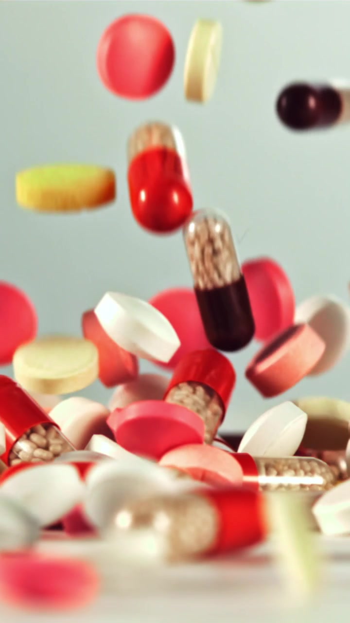 Colorful Pills and Capsules Falling in Slow Motion