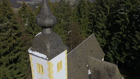 luftaufnahme einer kirche in den bergen, umgeben von dichtem wald, nach unten geneigte kamerabewegung, religion und spiritualität, mittelalterliche architektur