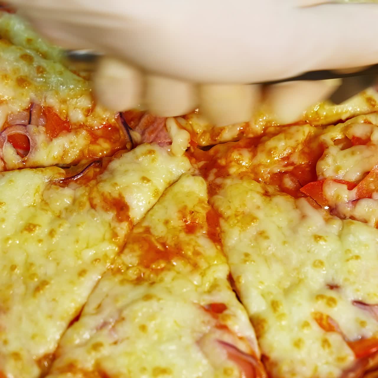 Yummy fresh pizza in a restaurant. Just now cooked pizza from oven cutted in pieces with pizza knife. Much cheese on the top