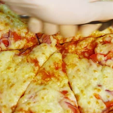 yummy fresh pizza in a restaurant. just now cooked pizza from oven cutted in pieces with pizza knife. much cheese on the top