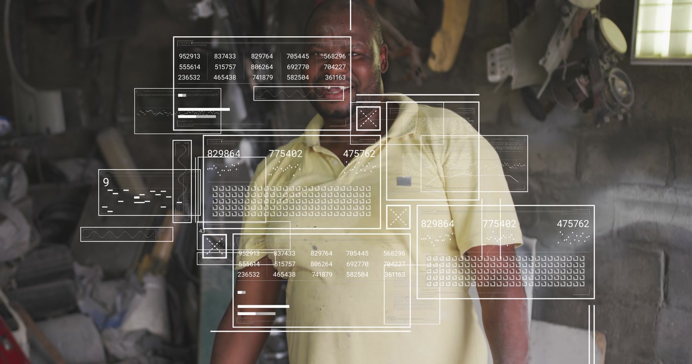 Workshop tech reacting to camera, smiling as HUD readouts, graphs and dial multiply displaying data