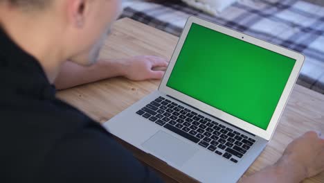 the man works remotely. green laptop screen. selective soft focus. the concept of distance education. surfing the internet