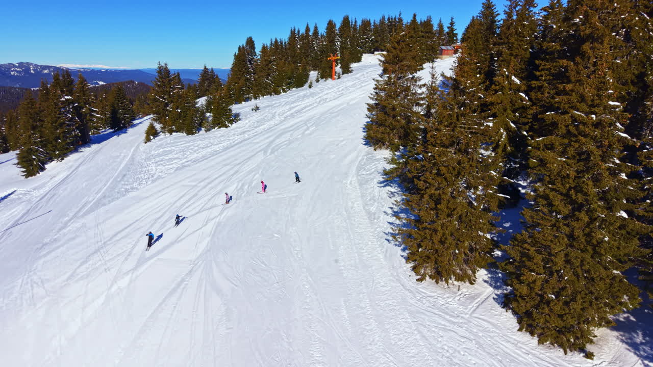 Veduta aerea di sciatori che scendono una pista da sci innevata
