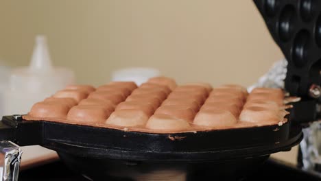 cerca de un gofre de burbujas que se hornea en una tostadora de gofres