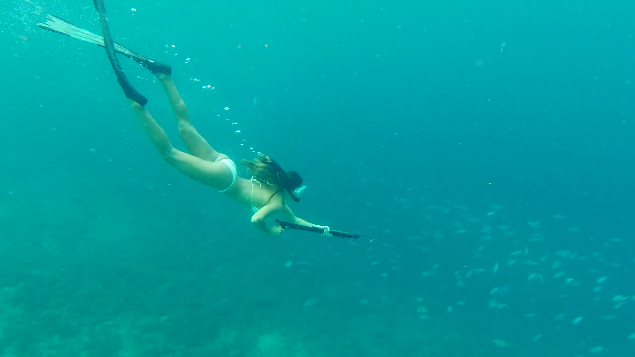 mujer de pesca con lanza bajo el agua