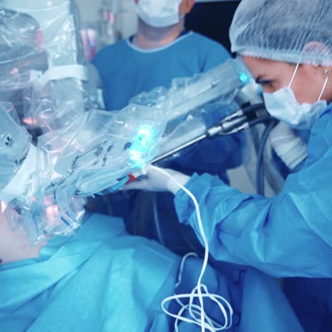 Medical operation involving robot. Specialist puts the robotic device into a medical machine in the operating room. Robotic surgery.