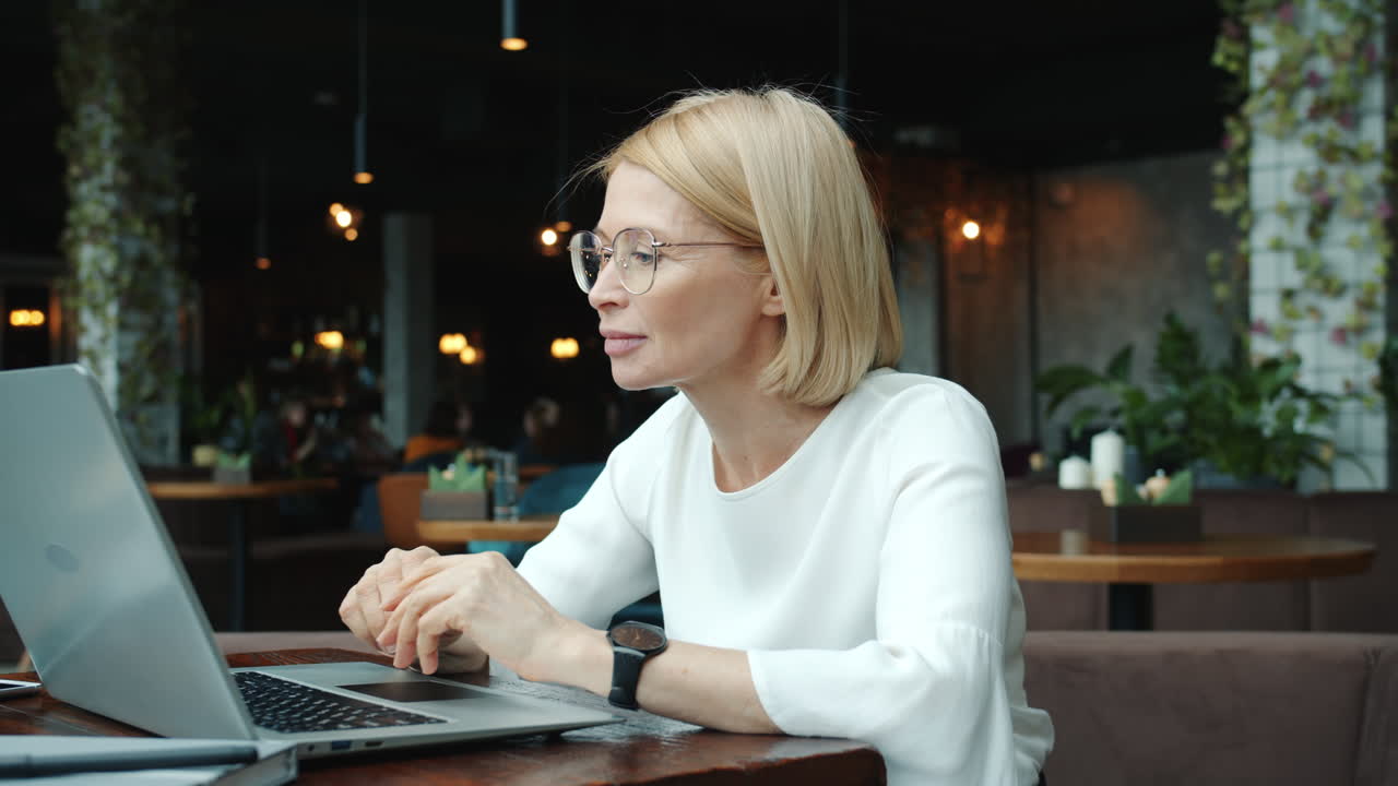 Woman Working on Laptop in a Cafe