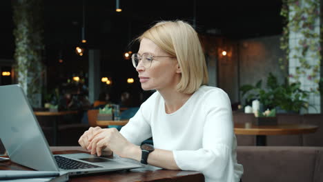 mujer trabajando en una computadora portátil en un café