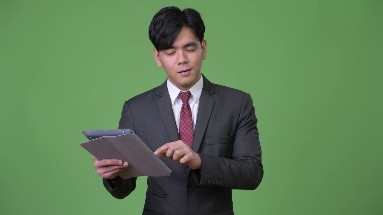 年轻帅气的亚洲商人使用平板电脑
