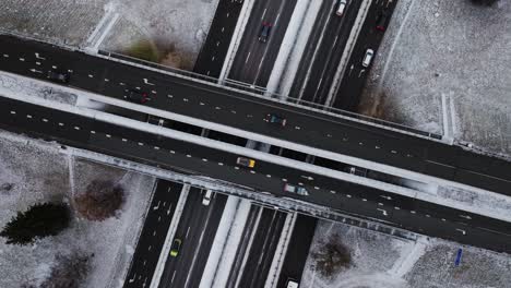 timelapse aerial shot of fast-moving vehicles on snowy highway, moving traffic