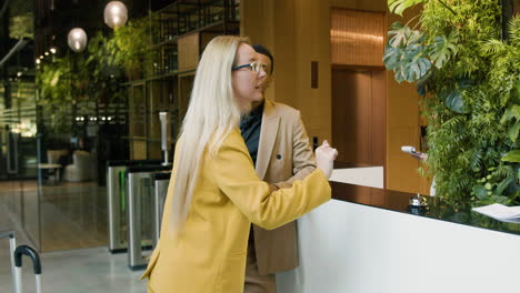 blonde woman and african american man talking in a hotel