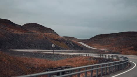 conduzca por la estrecha carretera de dos carriles a través de la tundra otoñal azotada por el viento