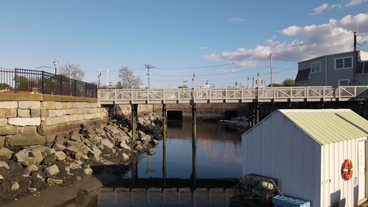 suave vuelo de drones hacia pilotes elevados de pasarelas, sobre aguas tranquilas del puerto