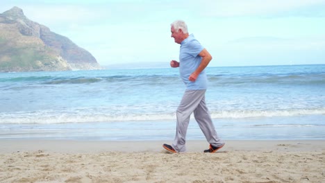 senior man jogging on the beach