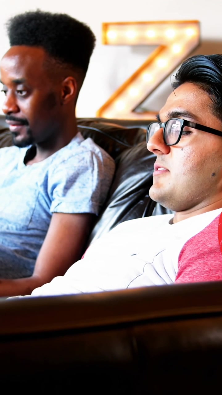 Animation of rainbow heart over gay couple using electronic devices