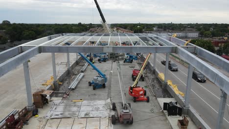 bridge-under-construction-in-minneapolis,-machinery,-boom-lift-and-construction-workers