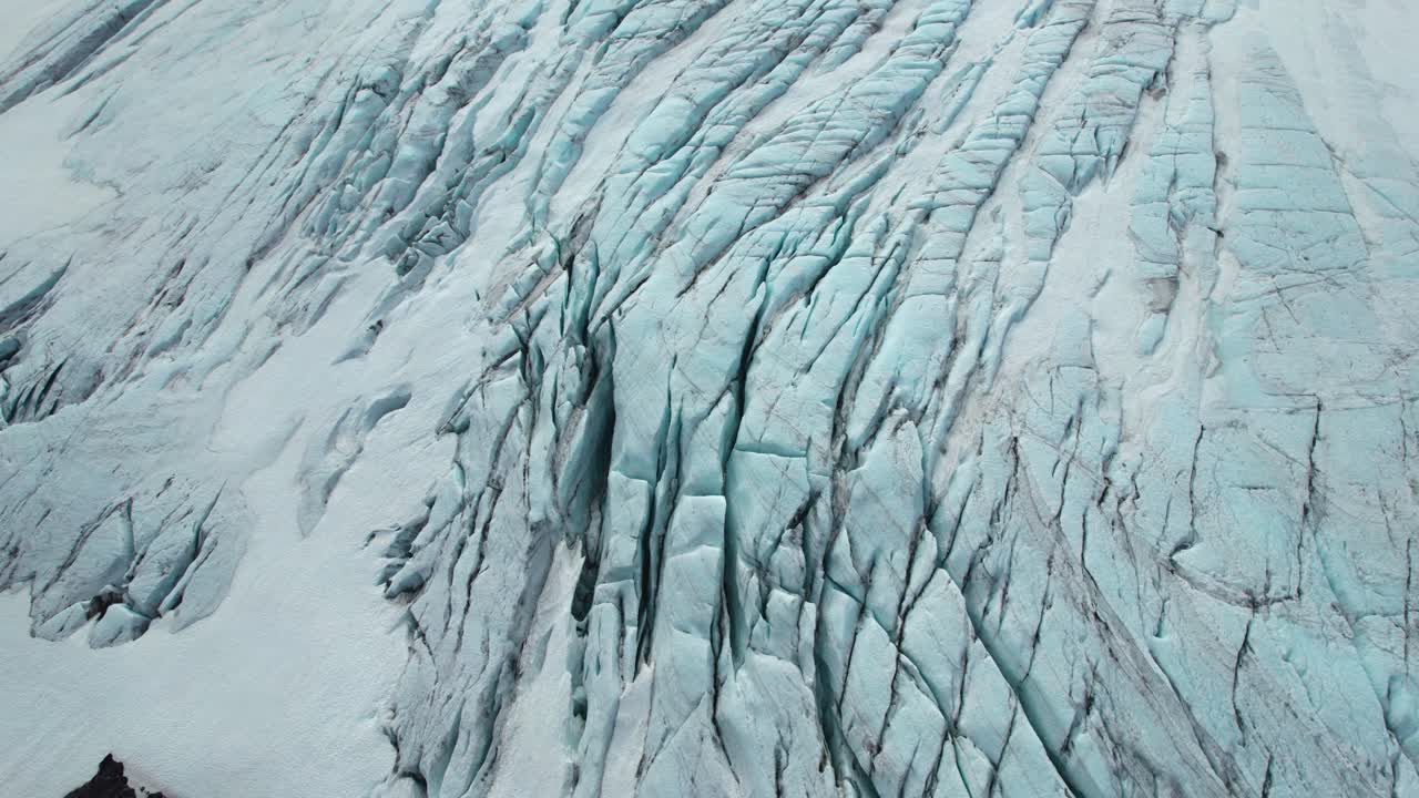 Aerial view of Iceland glacier crevasses with jagged formations and icy textures.