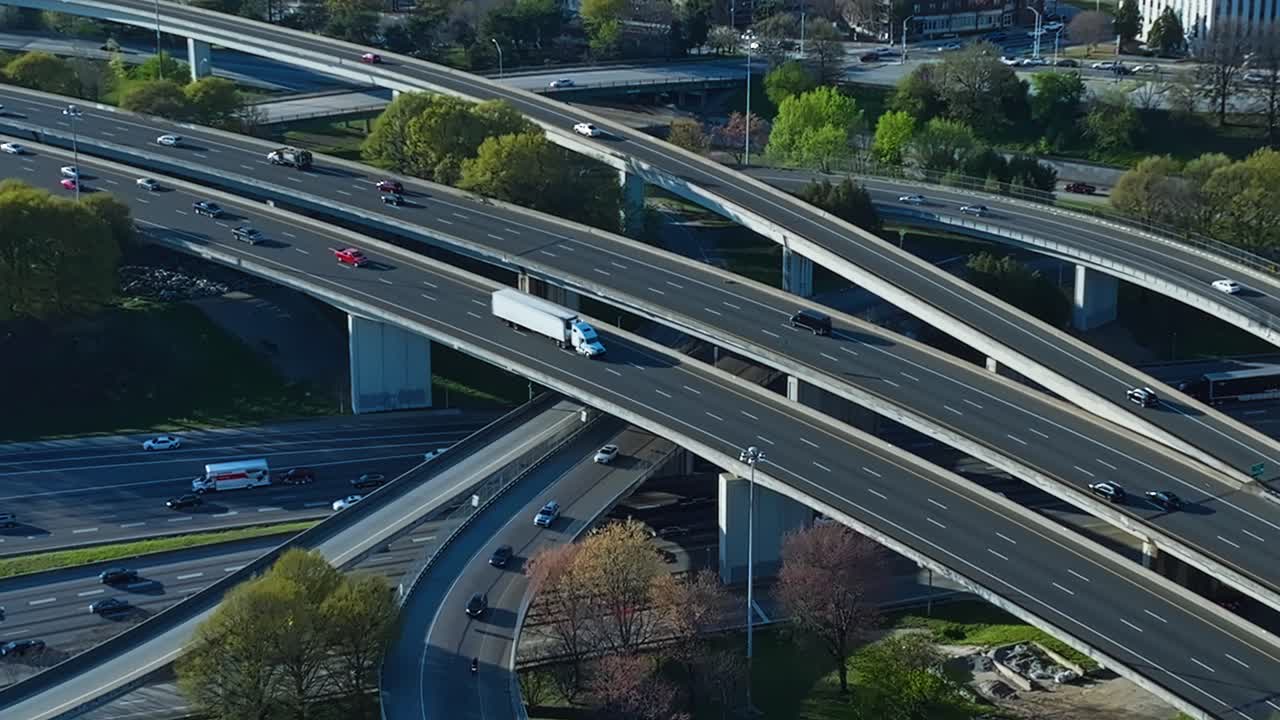 Aerial top down of cars on highway street and interstate in Atlanta, Georgia. Spring day with trees and Downtown Skyline in backdrop. Aerial tilt up wide shot.