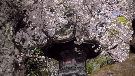 close up stunning shot of japanese stone pillar covered in pink sakura flowers