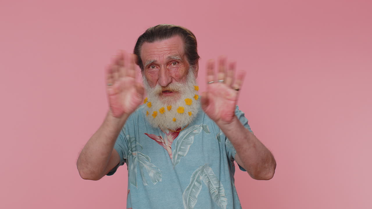 hombre mayor sonriendo amigablemente a la cámara y agitando las manos gestando hola o adiós, bienvenida