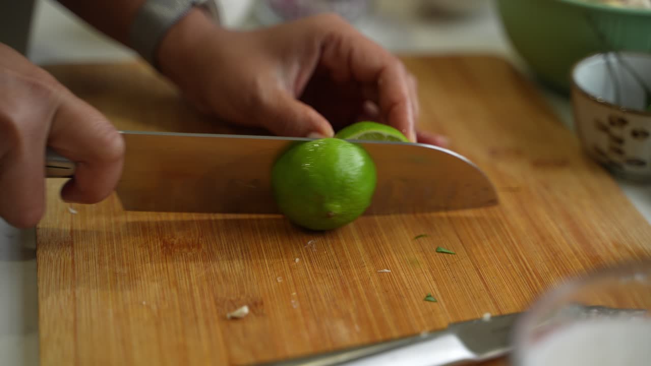 Cutting of green lemon on two halves. Closeup view.