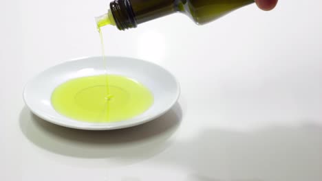 Olivenöl-Aus-Einer-Flasche-Auf-Einen-Teller-Gießen