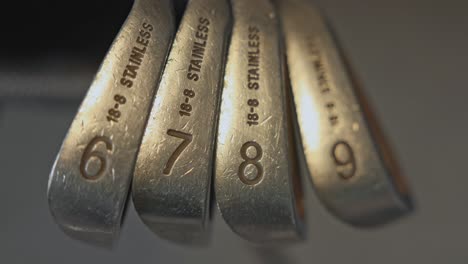 close-up shot of higher-lofted irons inline within a golf bag