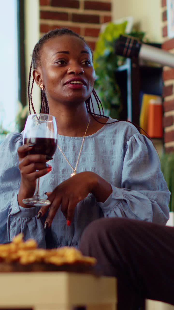 Vertical video Diverse friends at house party paying attention to interesting story shared by woman