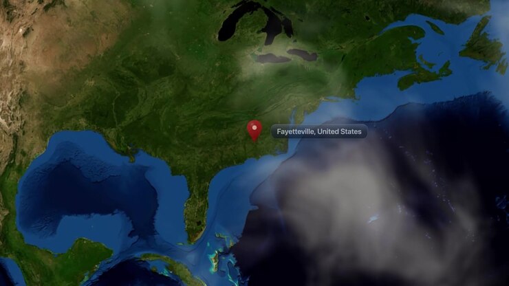 Satellite view zooms from outer space directly to a pin marker over Fayetteville, North Carolina. Includes NASA public domain imagery.