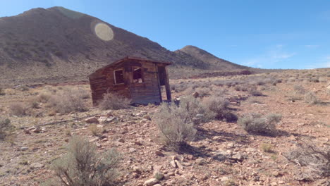 panning shot of an outhouse ruin in the arizona desert