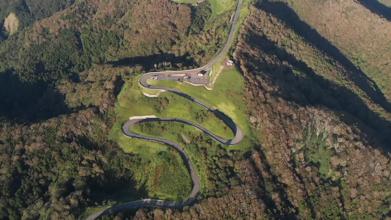 Aerial tops down curved zig zag mountain road in green mountain Japan landscape