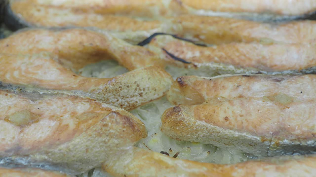 Tranci di salmone dorati che arrostiscono in padella