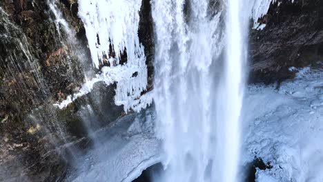 Vista-Aérea-Por-Drones-De-Una-Hermosa-Cascada-En-La-Invernal-Islandia,-Tierra-De-Fuego-Y-Hielo