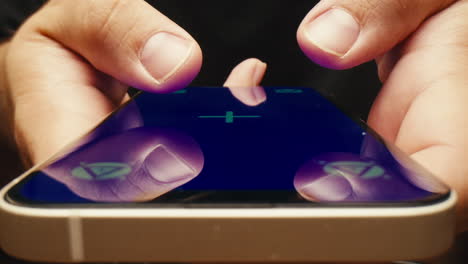 close up of hands playing a game on a smartphone