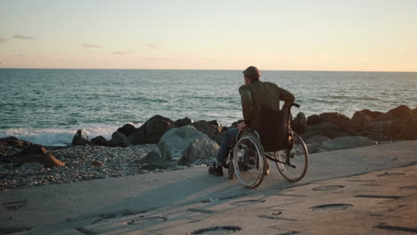 disabled man enjoying sunset by the ocean