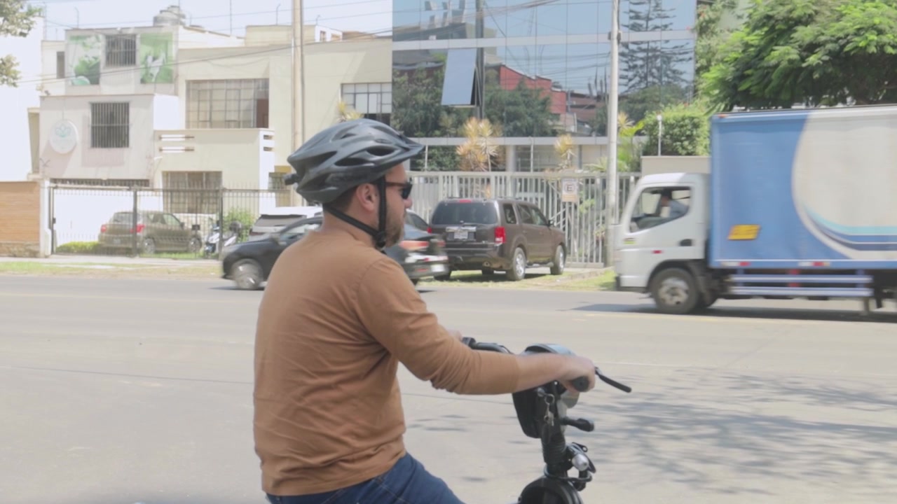 Man in Helmet Waiting on Electric Scooter on a Busy City Street