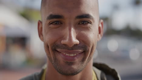 close-up-portrait-of-handsome-hispanic-man-smiling-cheerful-looking-at-camera-happy-enjoying-warm-summer-on-urban-beachfront-street