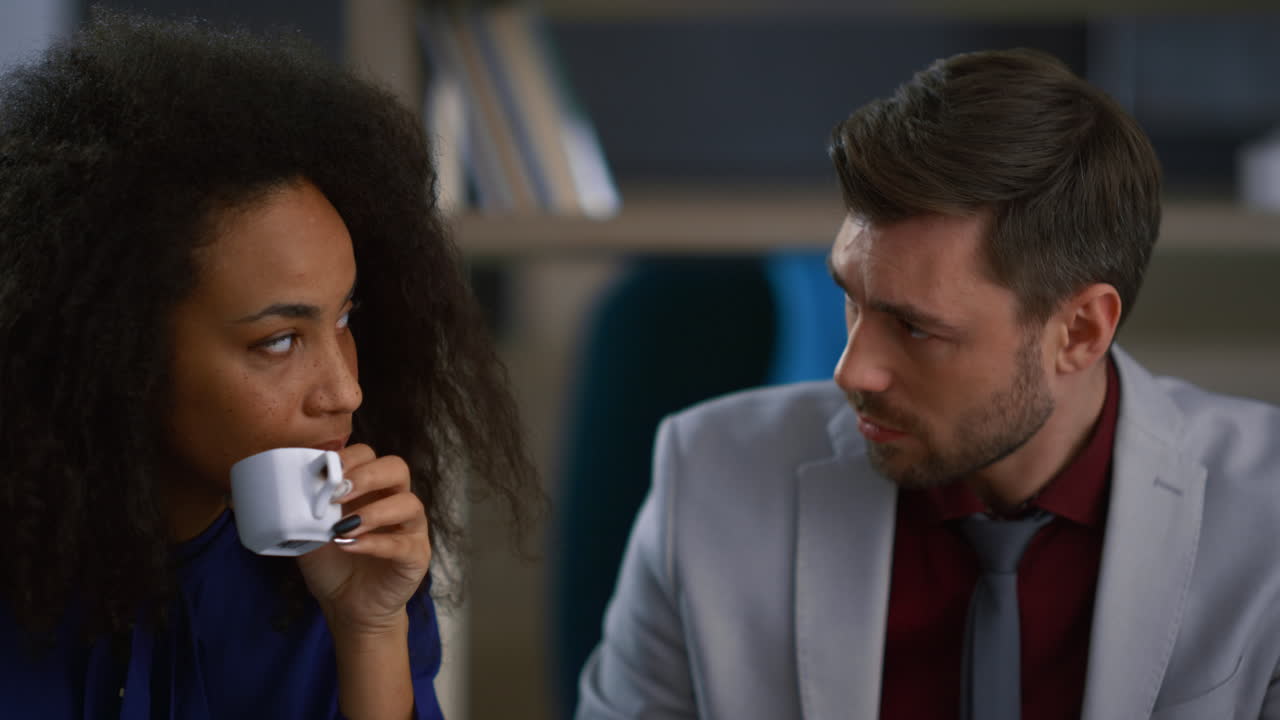 una pareja de ejecutivos multiétnicos trabajando juntos resolviendo problemas en un café de coworking.