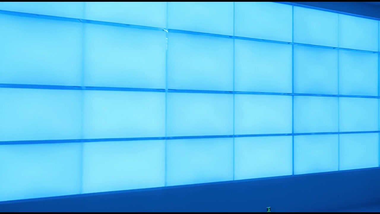 Ufficio moderno vuoto con parete illuminata di blu e scrivanie
