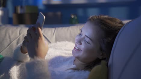 una joven feliz y alegre mirando el teléfono.